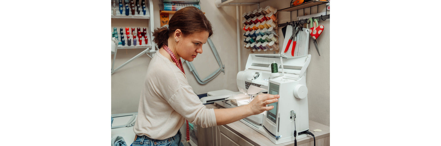 woman sitting in front of an embroidery machine