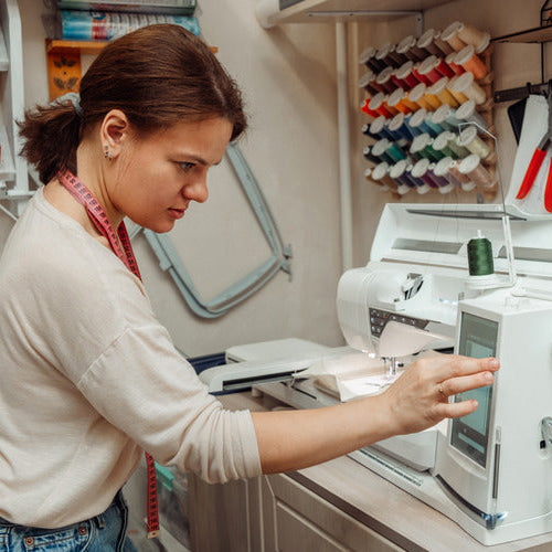 woman sitting in front of an embroidery machine
