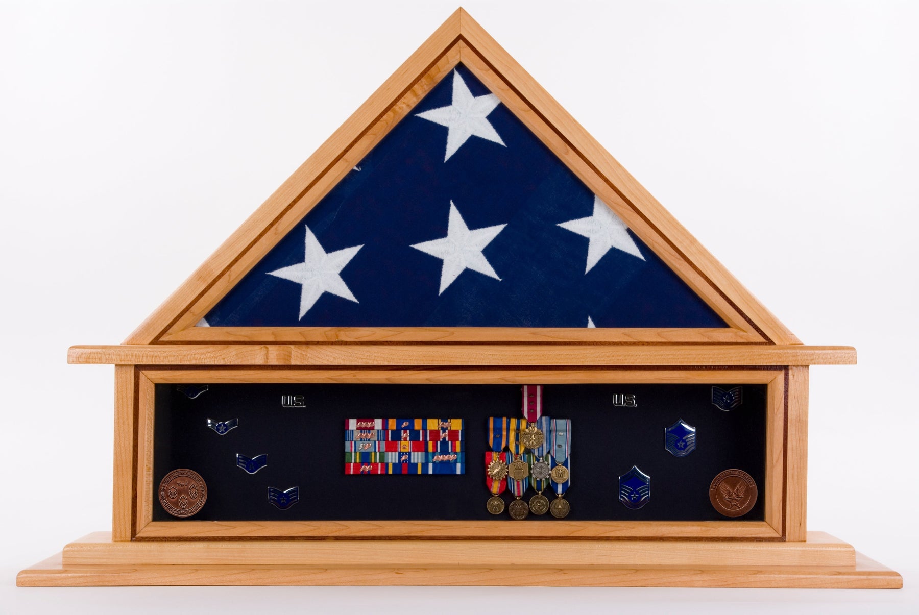 shadow box filled with a triangle folded American flag on top of military medals and pins