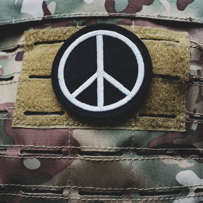 Peace Sign patch on camouflage backpack