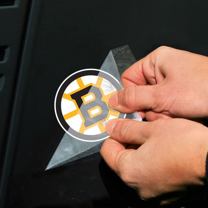 Person applying a sports team logo decal to a vehicle