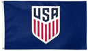 A blue flag featuring a large white shield with the letters USA in navy and red vertical stripes below, shown against a plain white background.